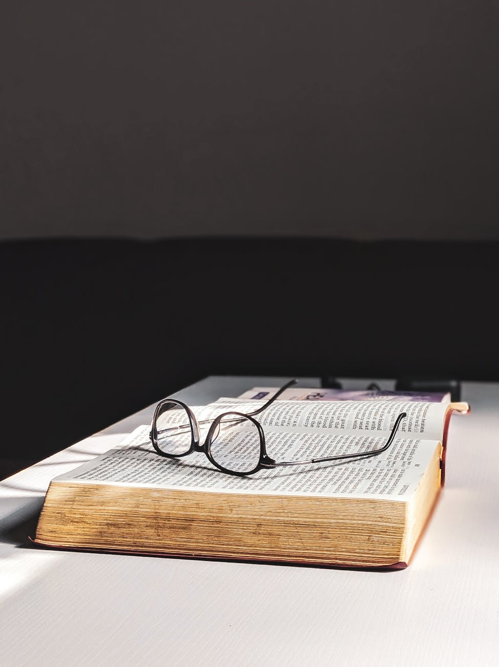 Best 50 Trivia Questions for Adults That'll Stump Even the Smartest Minds 3 eyeglasses on top of an opened book